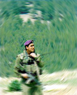 Photo of uncomfortable-looking soldier standing in front of Jebal Abu Ghnaim
