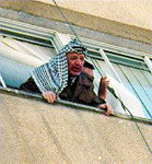 Photo: Arafat peeking out of a window.