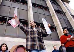 Photo: Democratic Student Pole leader holds up photos of alleged PA torture during election debate.