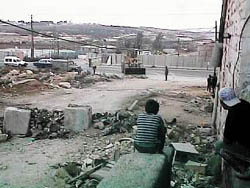 Photo: Local residents watch the bulldozer seal them in