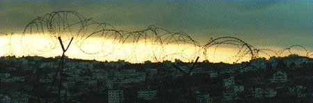 Photo: Sunset over Hebron, seen through a barbed wire fence at 'the Amara', the former Israeli military headquarters