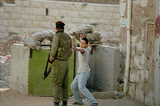 Photo: Palestinian youths being searched outside CPT offices