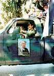 Photo: Police truck loaded with children and decorated with posters of Arafat