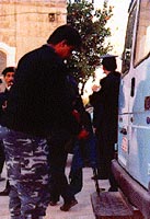 Photo: Palestinian policeman adjusts his rifle on the back of a car