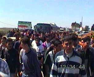 Photo: Birzeit students get out and walk after their buses were stopped by Palestinian Police