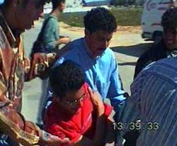 Photo: Student overcome by teargas on the way to an ambulance.