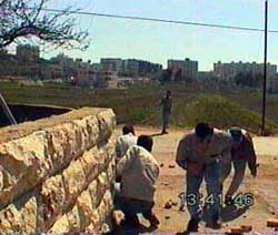Photo: Student protestors duck behind a wall.